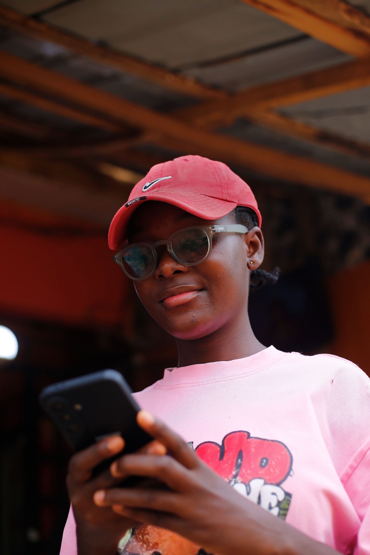 A confident young Nigerian seller using BagUp in a Lagos market at golden hour